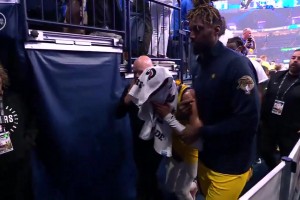 哈利伯頓在隊友們的攙扶下離開球場，用毛巾掩面，相當難受啊